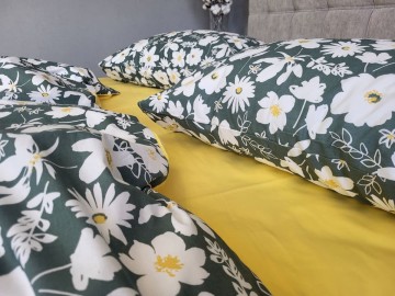 Premium satin bed linen. Perfectly smooth, shiny and soft. The dark green background with bright daisies is perfectly complemented by a plain yellow sheet. All sizes available, as well as a fitted sheet.